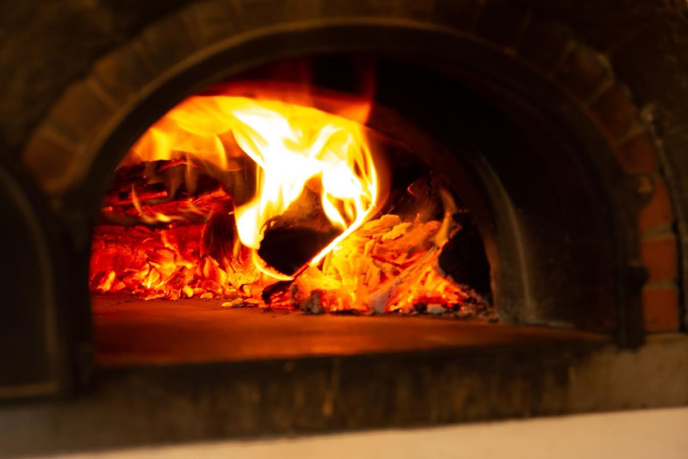 A wood fire burning inside the pizza oven