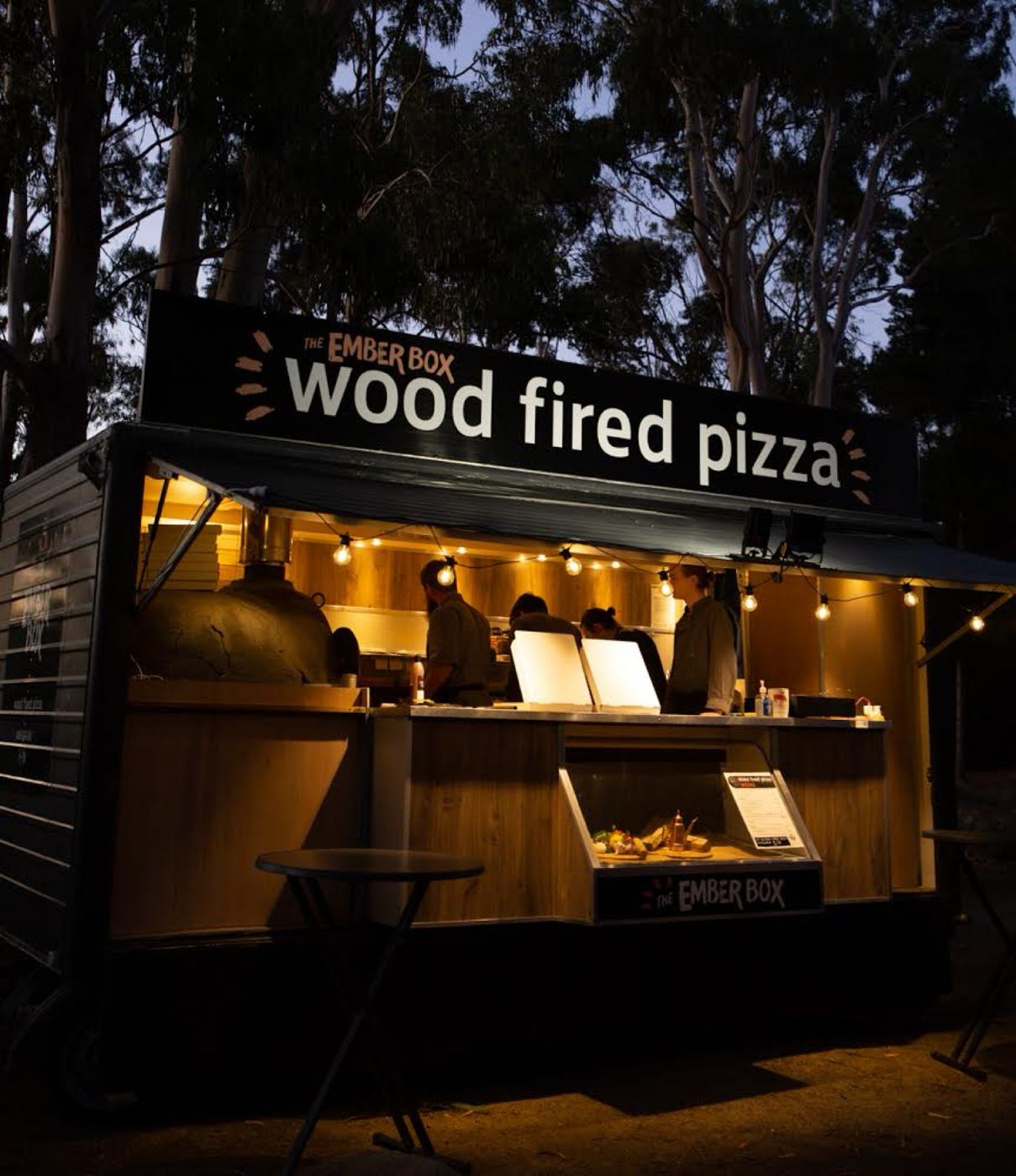 The Ember Box trailer lit up under festoon lights at night